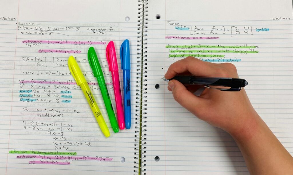 Person writing notes with colourful highlighters