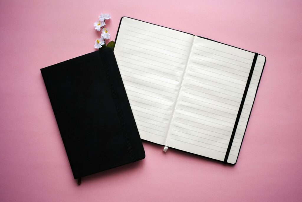 Notebook with pen and flower illustrating journal stationery, not a particular stencil product