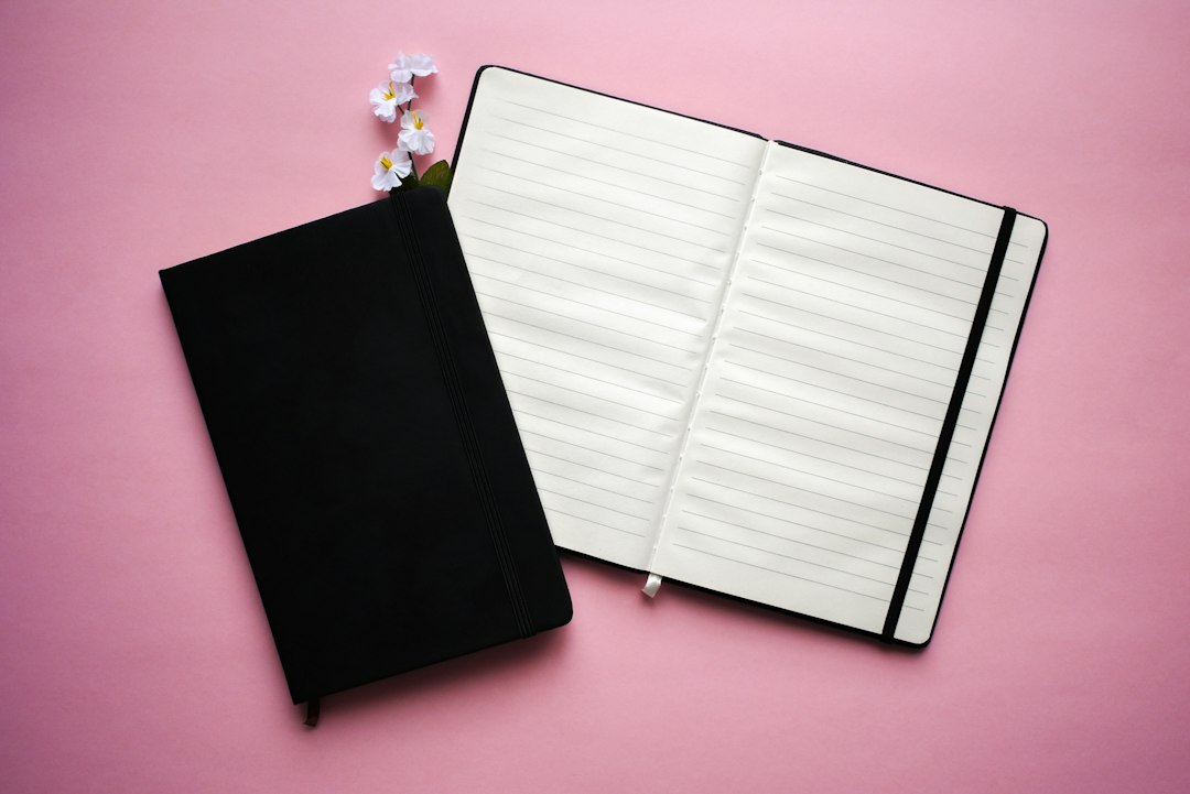 Notebook with pen and flower illustrating journal stationery, not a particular stencil product