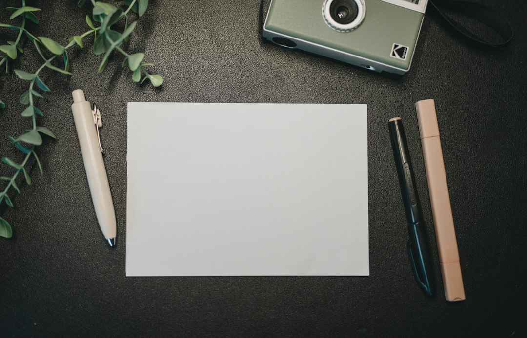 Camera with blank paper and a pen illustrating organizing memories, not a photo corner product