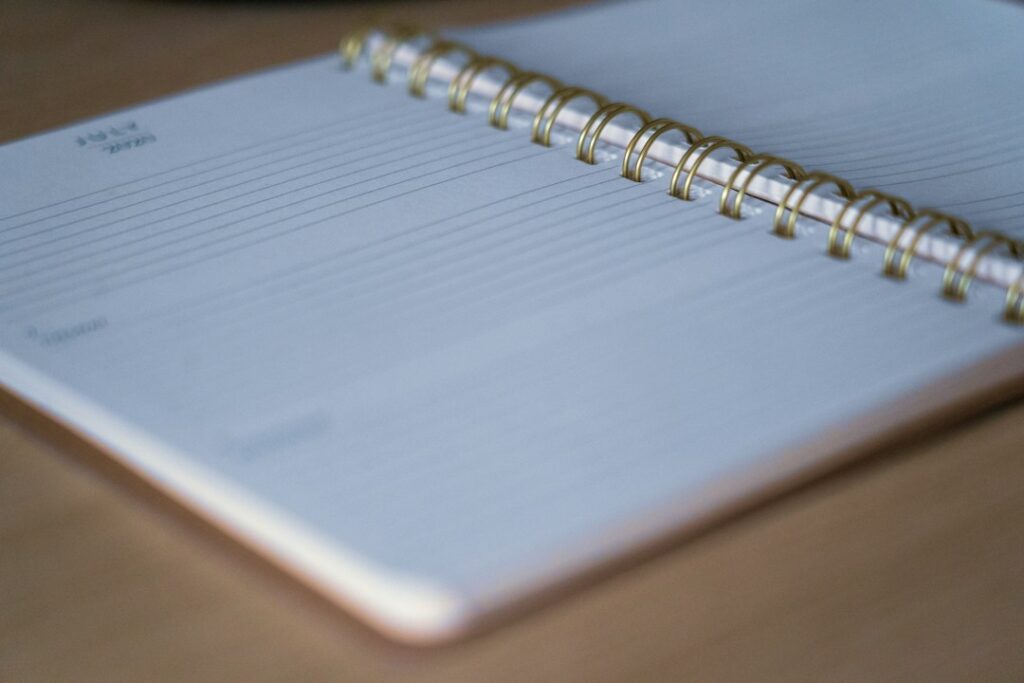 Open ring binder planner with paper pages on a desk