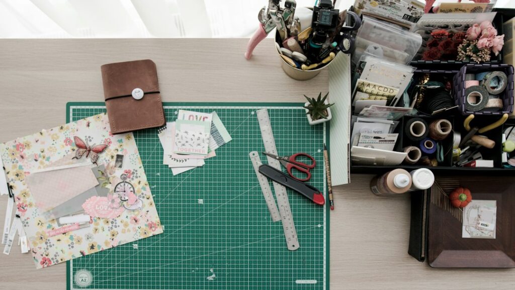 Paper craft and scrapbooking supplies spread across a workspace