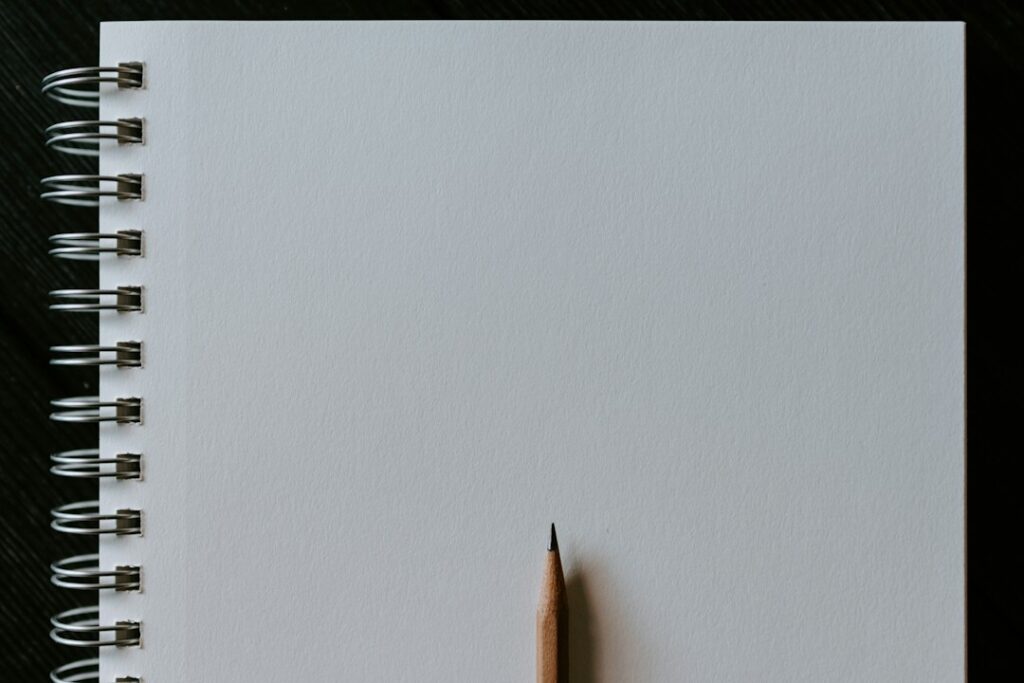 Pencil resting on a sketch notebook, illustrative photograph