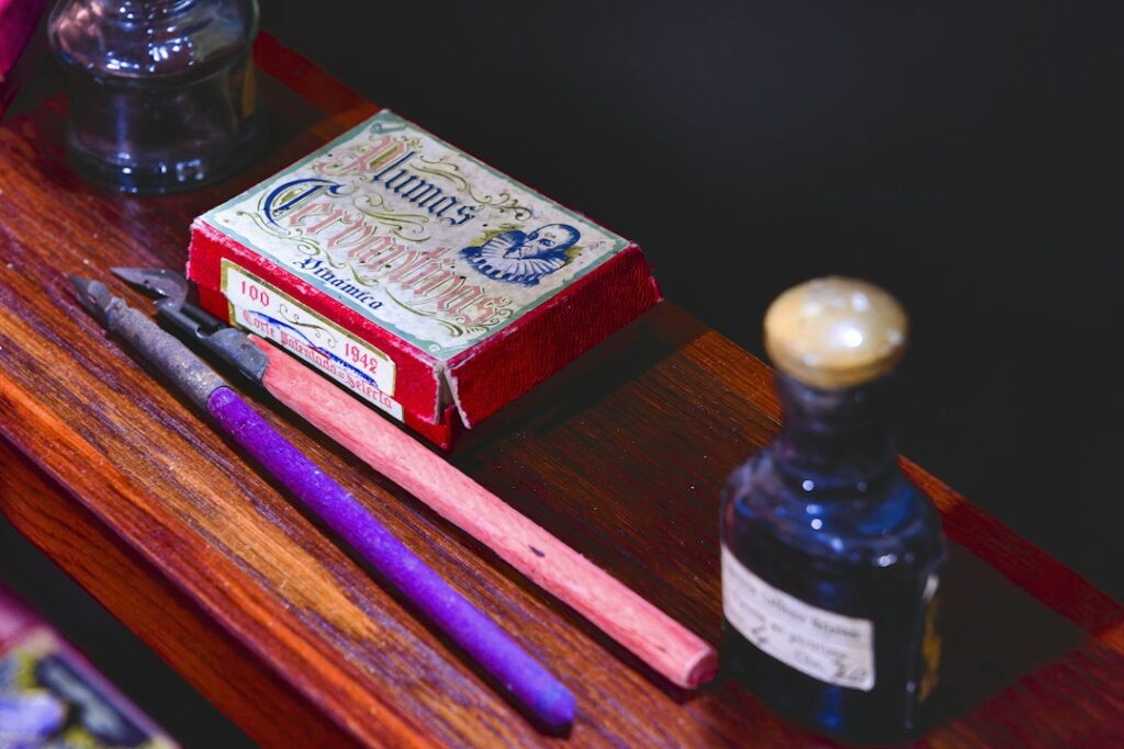 Writing instruments and ink-related accessories on a wooden surface