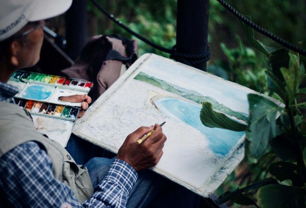 Artist painting with brush, illustrating watercolour techniques