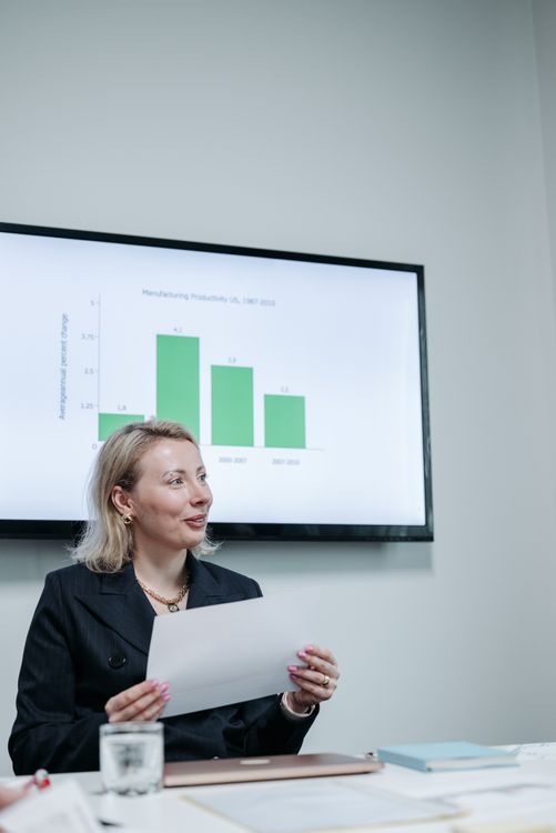 Business professional holding presentation documents during a meeting