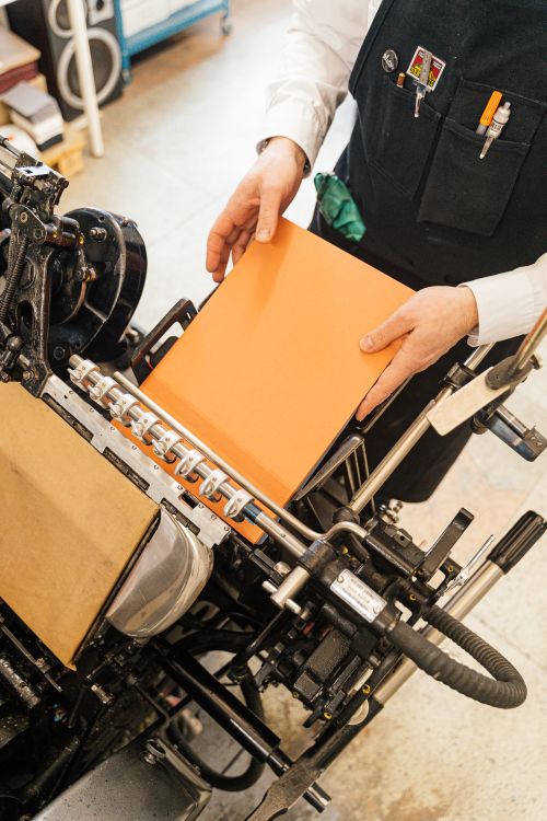 Person feeding paper into a binding machine