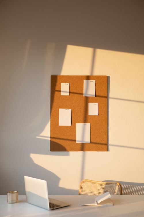 Warm home office workspace with a cork board and pinned notes