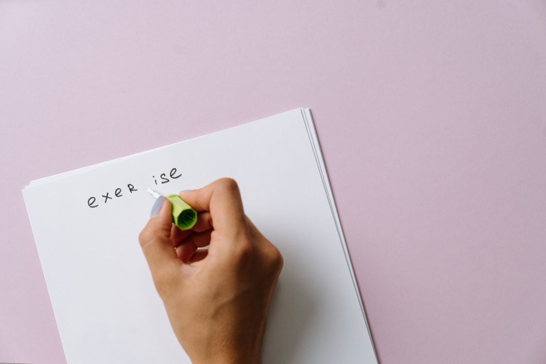 Hand using white correction fluid to fix a written mistake