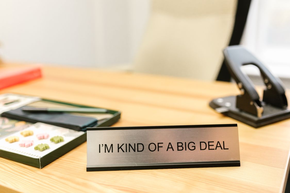 Office desk with a visible name plate and stationery