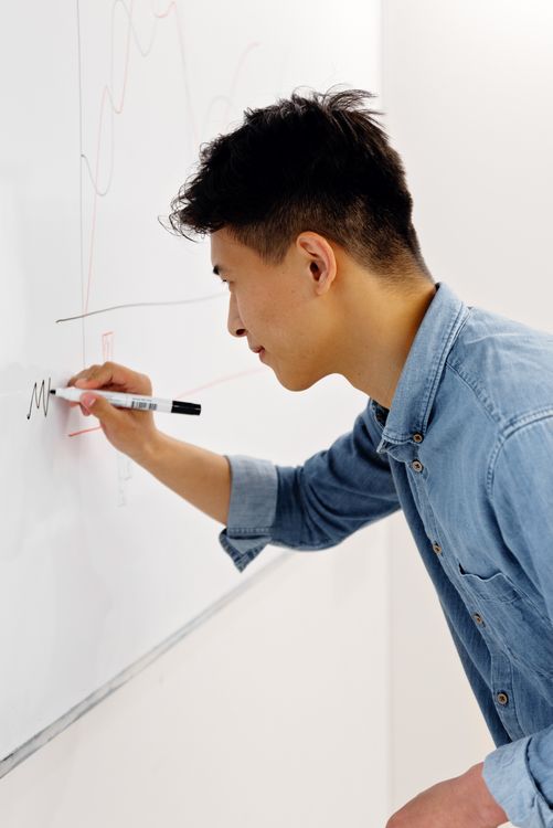 Man writing on a whiteboard with a marker