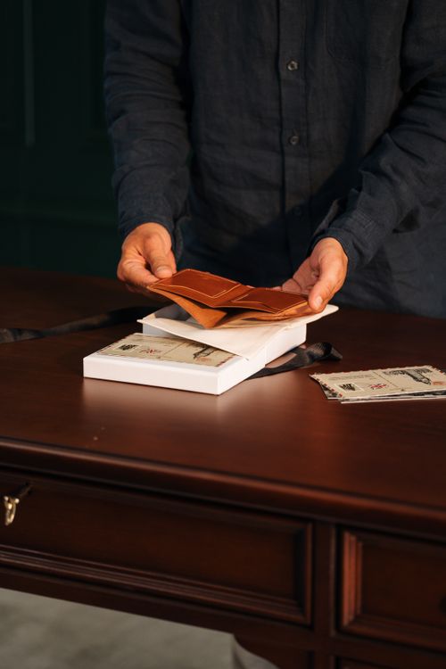 Person organizing envelopes and letters on a wooden desk