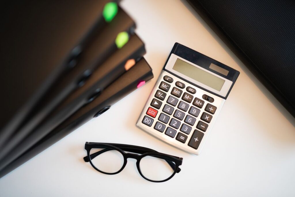 Calculator, folders, and office documents arranged on a desk