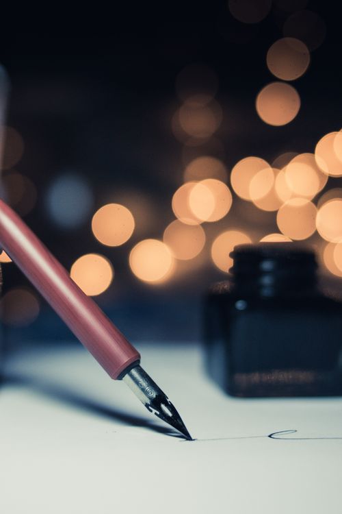 Close-up of a fountain pen and ink bottle