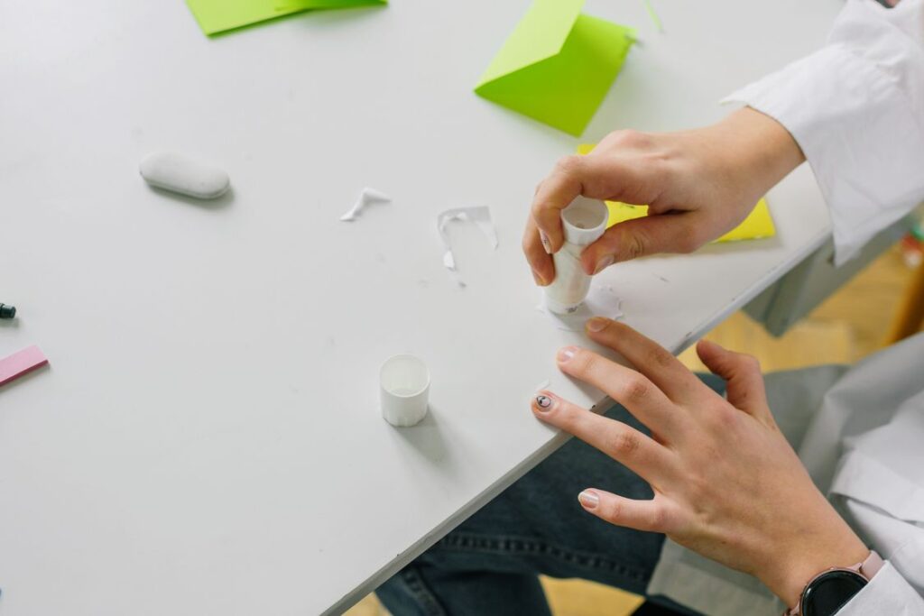 Hands applying a glue stick to paper during a craft project
