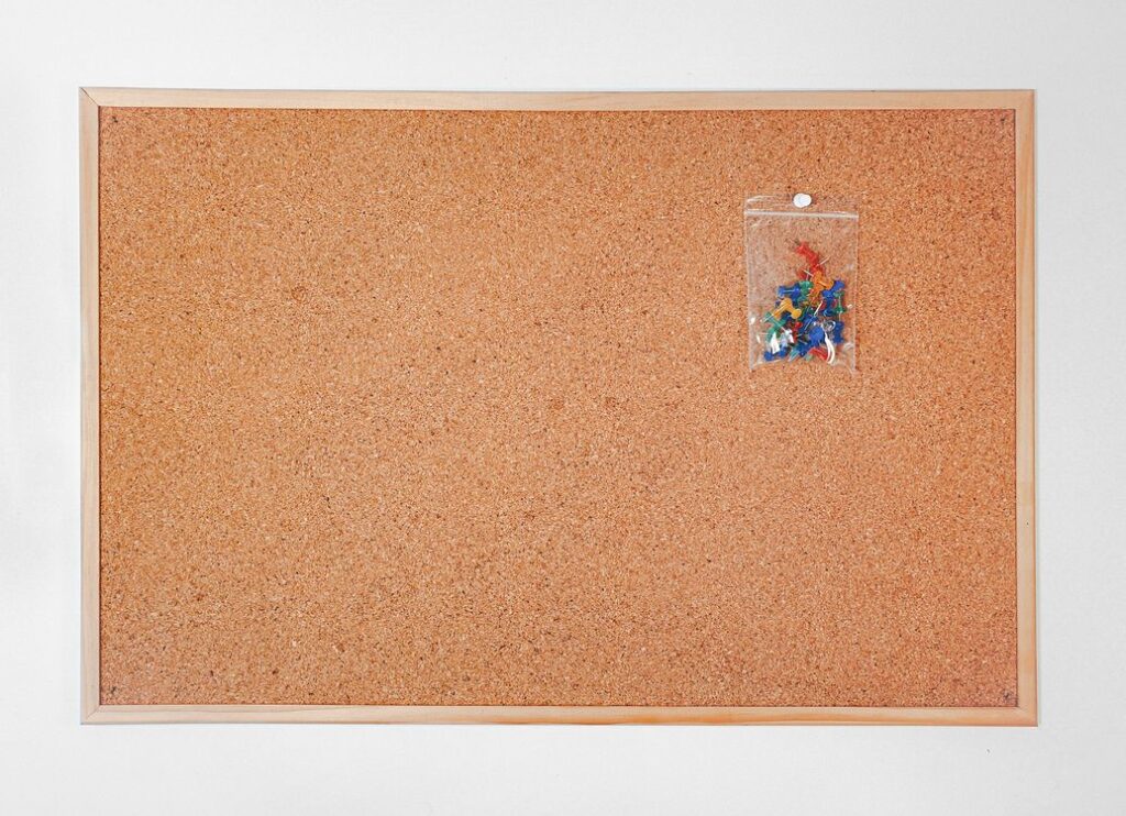 Colorful push pins on a cork board