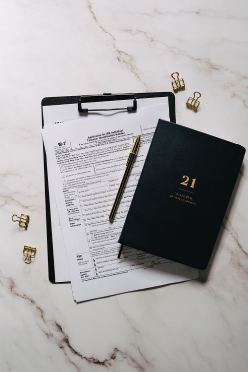Clipboard with documents and notebook arranged neatly on a desk
