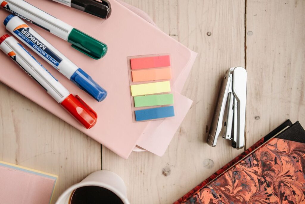Bright office supplies including a stapler on a wooden desk