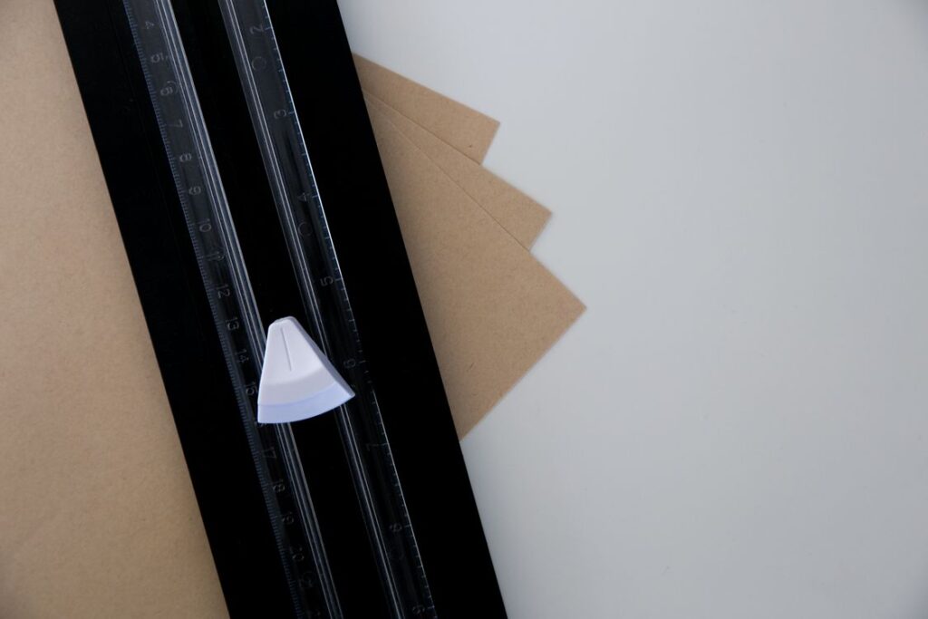 Paper trimmer cutting brown paper on a work table