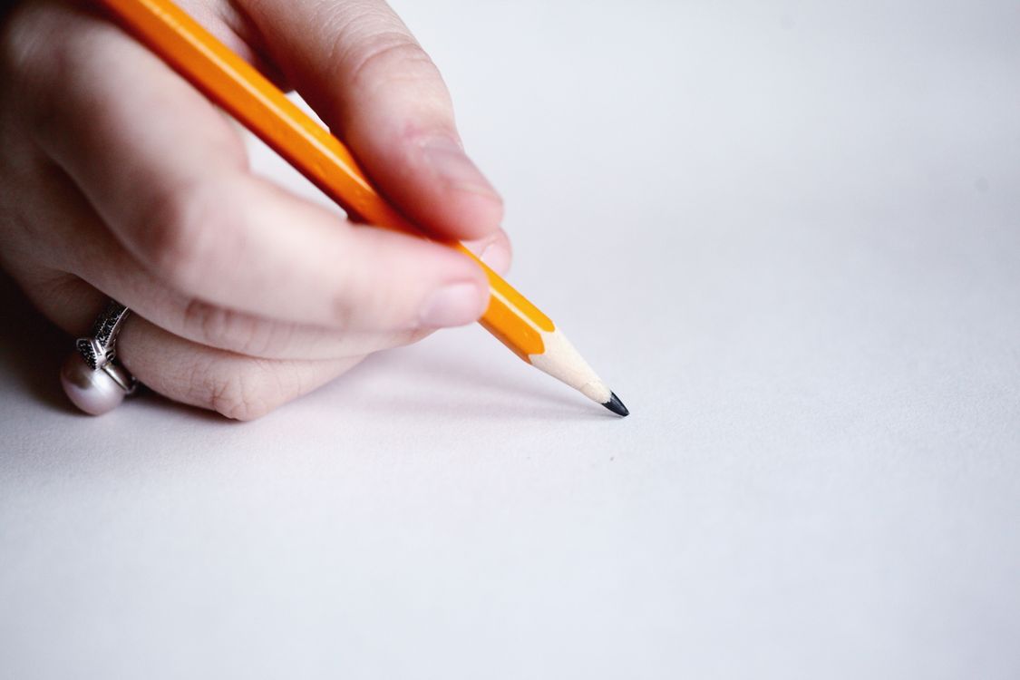 Close-up of a hand holding a pencil with a visible writing grip