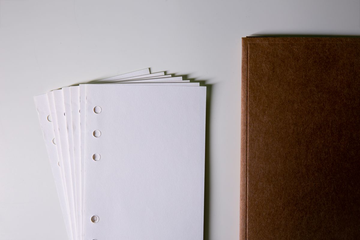 Loose-leaf paper beside a notebook